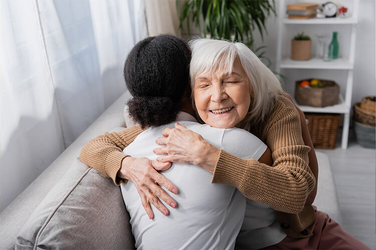 senior woman hugging her caretaker