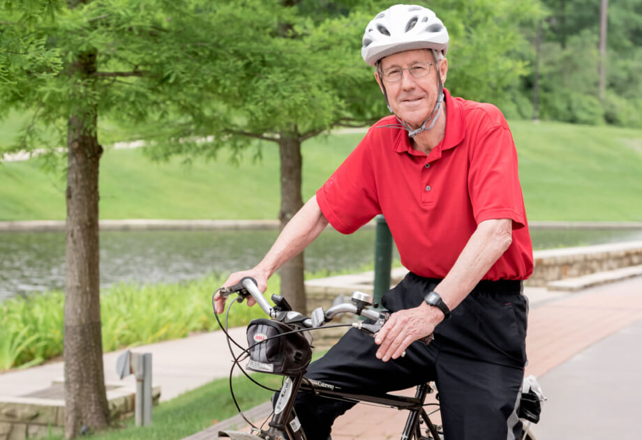 Senior man riding bike through paths