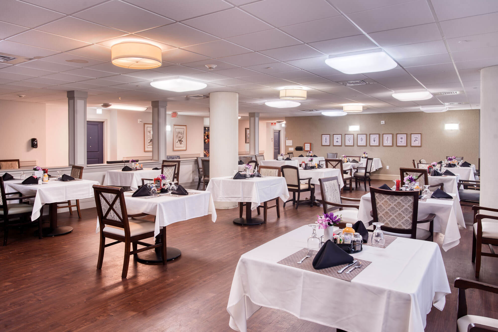 Elegant dining room with white tablecloths in a senior living community.