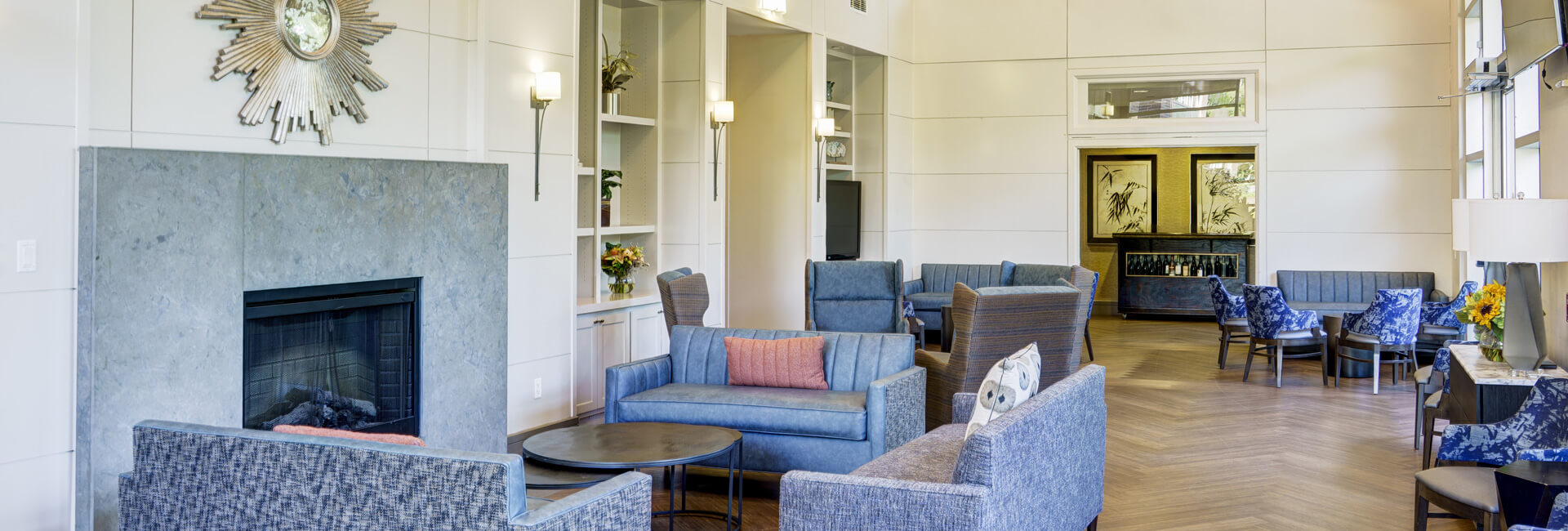 Elegant common area with cozy seating, a fireplace, and decorative wall art.