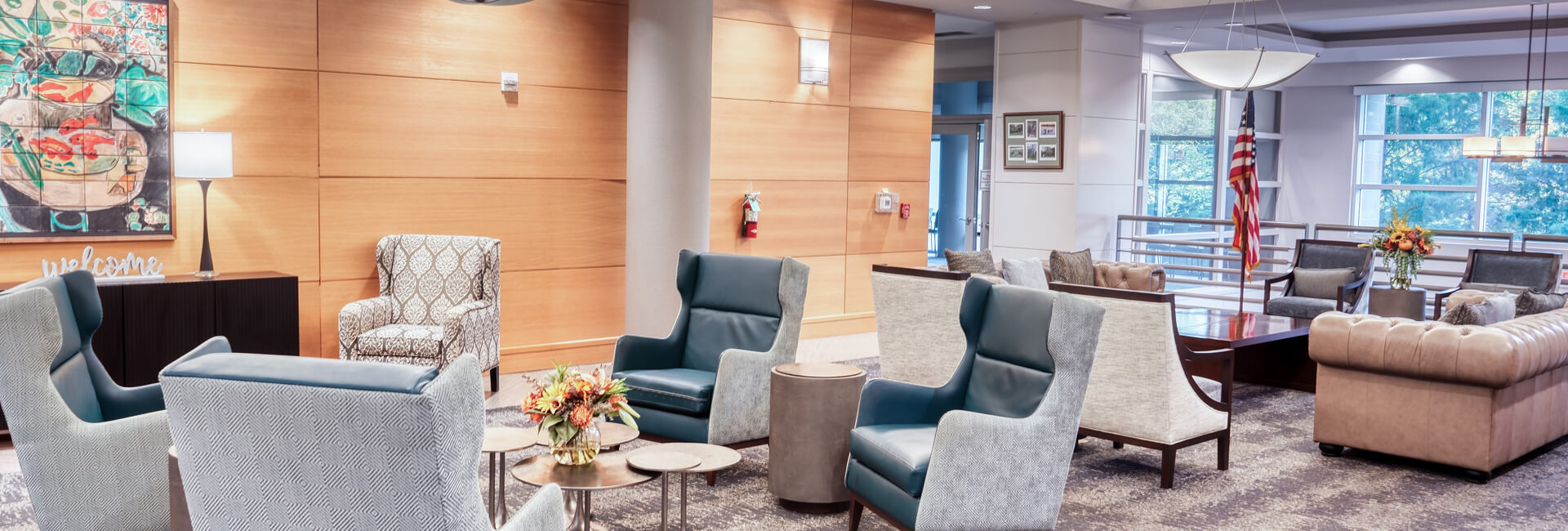 Welcoming community space with modern chairs, art, and large windows.