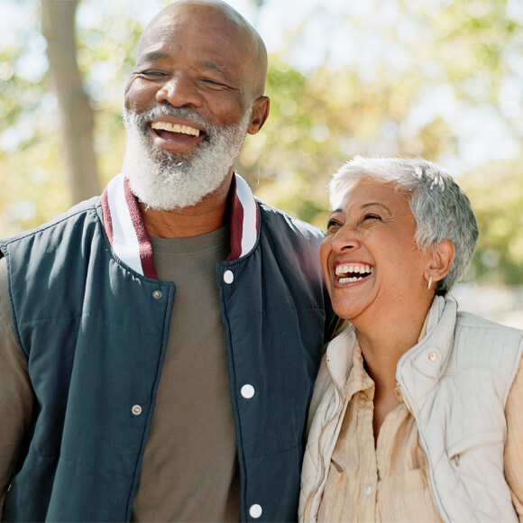 Smiling senior couple enjoying a sunny day outdoors in a community garden.