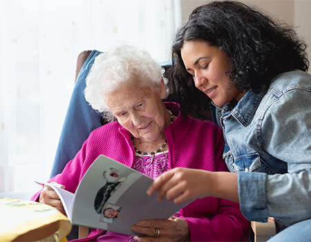 Senior reading with her adult child.