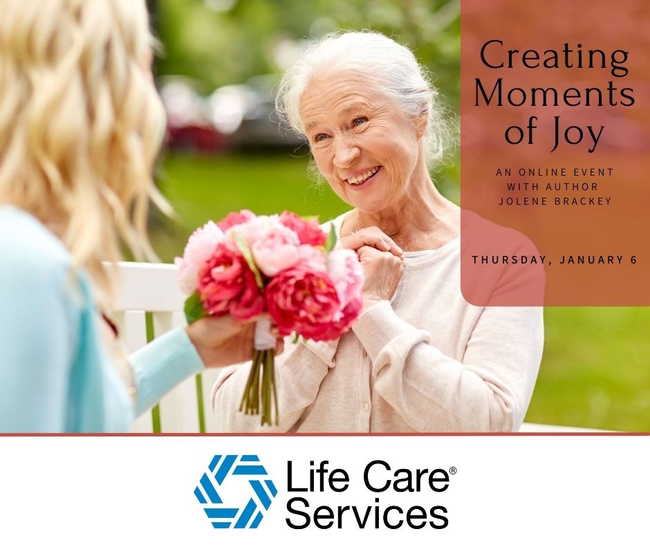 Elderly woman smiling while receiving a bouquet of flowers from a younger person outdoors.