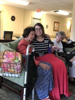 Group of two elderly women and one younger woman sitting together in a common area of a unit.